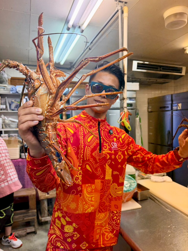 鮮度抜群の伊勢海老をカメラに向けるマイケル社長